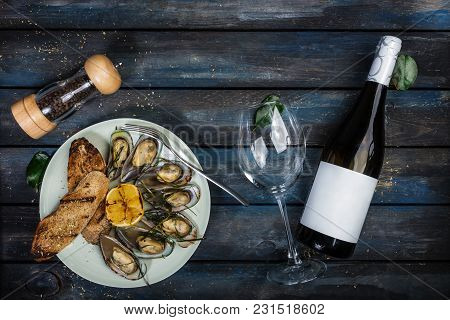 Mussels And Bread Toasts On On A White Plate. Served With Half Grilled Lemon, Fork And Leaves Of Kaf