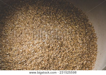 Grinded Grains Of Barley Malt Close-up. Craft Beer Brewing From Grain Barley Pale Malt In Process. A