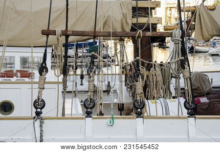 Boat Details And Roaps In Barcelona Port At Mediterranean Sea In A Sunny Day. White Yacht Are In The