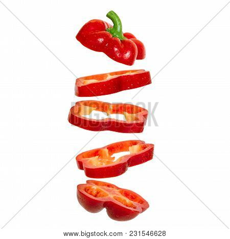 Creative Concept With Flying Red Paprika. Sliced Floating Pepper. Levity Capsicum Vegetable Isolated