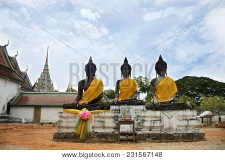 Three Buddha Brother Statue Beside Ubosot And Chedi Of Wat Phra Borommathat Chaiya Temple In Chaiya 