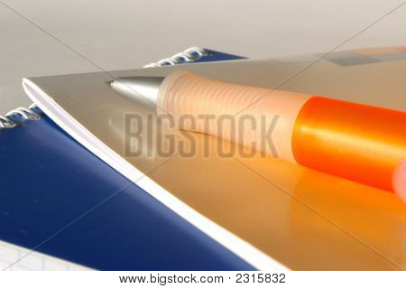 Dos cuadernos y pluma naranja