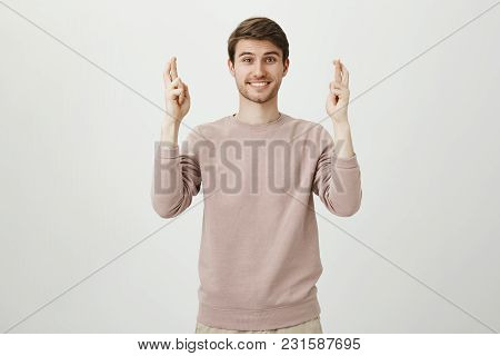 Portrait Of Charming Caucasian Male With Bristle Raising Hands With Crossed Fingers And Smiling, Exp