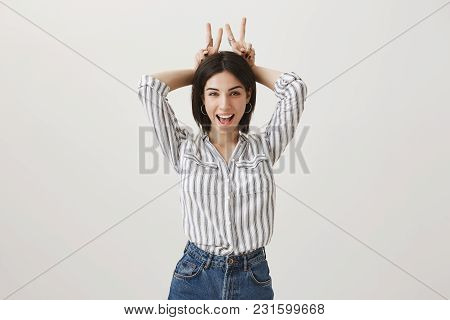 Attractive European Woman With Short Dark Hair And Sense Of Style Standing Over Gray Background, Smi