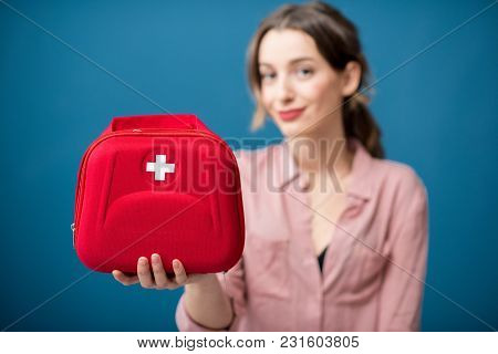 Portrait Of A Woman With First Aid Kit On The Blue Wall Background