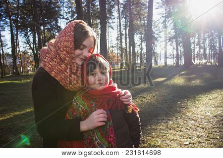 Young Pretty Girl With Daughter At Red Scarf On Her Head In The Spring Forest