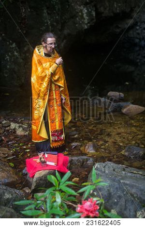 KOH CHANG, THAILAND - MAR 9, 2018: Orthodox priest during sacrament of spiritual birth - Baptism. There are currently 10 Orthodox parishes in Thailand, Orthodoxy is practiced by 0.002% of population.