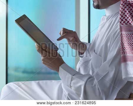 Saudi Arabian Man Using Tablet Beside Window