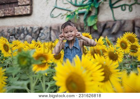 Cute Asian Little Girl Smiling In Sunflower Field
