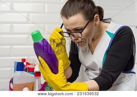 Housewife Woman Does The Cleaning With Interest Reading The Instructions On The Detergent.