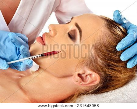 Filler injection for female face. Plastic aesthetic facial surgery and in clinic. Beauty woman giving injections in cosmetology room.