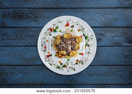 Mushroom Beef Stroganoff, With Champignons And Potato Pancakes, Served On The White Plate With Woode