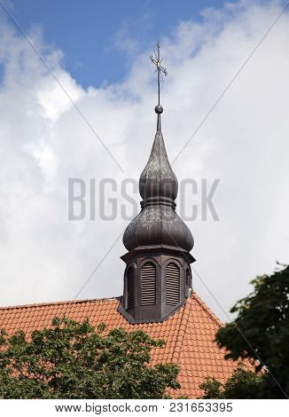 Golden Cross Of A Church On Red Tile Roof