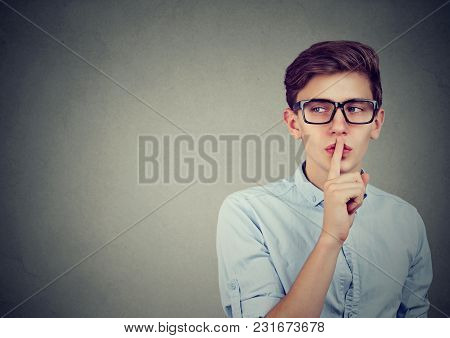 Secret Guy. Man Saying Hush Be Quiet With Finger On Lips Gesture Looking To The Side Isolated On Gra