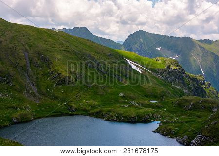 Lake Capra In Fagarasan Mountains Of Romania. Beautiful Summer Scenery On A Cloudy Day. Popular Tour
