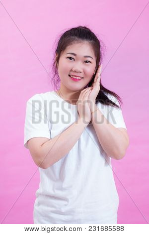 Portrait Of Beautiful Young Asian Woman Black Hair Wear A White T-shirt. Rubs Her Palms Near Face. E