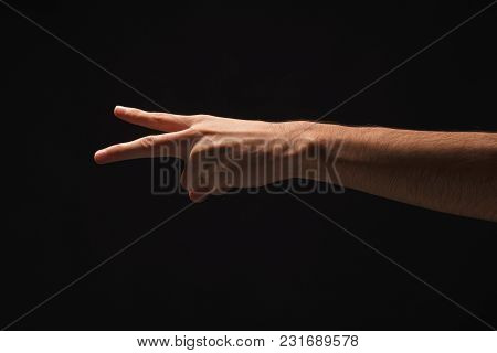 Male Hand Showing Two Fingers, Number Two Isolated At Black Background. Counting, Gesturing, Enumera