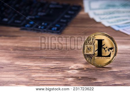 Criptocurrency Conceptof Physical Golden Litecoin Coin On Wooden Background Next To Keyboard And Dol