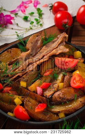 Fried Potatoes With Bacon And Fresh Tomatoes In The Frying Pan. Wooden Rustic Background. Top View.