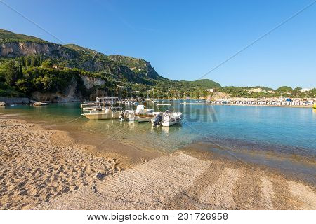 Boats Moored At Alipa Beach In Paleokastritsa Bay With Sand And Crystal Sea Water. Corfu Island, Gre