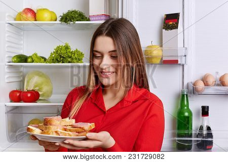 Happy Woman Holds Plate With Ready Sandwhiches, Wears Red Blouse, Going To Have Snack, Stands In Fro