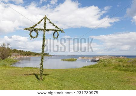 Tiny Maypole In The Swedish Archipelago, Blue Sky And White Clouds In The Background