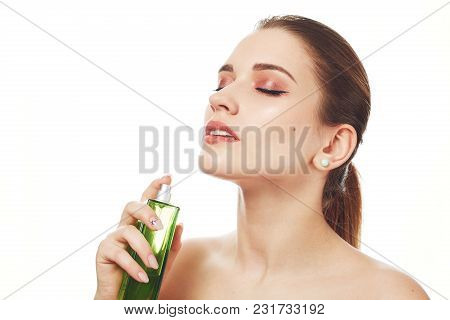 Portrait Of Pleased Adorable Woman With Wonderful Make Up, Uses Her Favourite Parfume, Looks Beautif