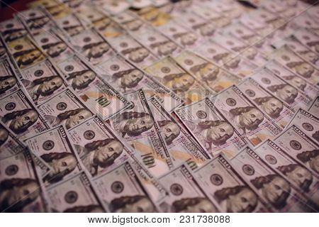 Hundreds Of New Benjamin Franklin 100 Dollar Bills Arranged Randomly With The Portrait Facing Upperm