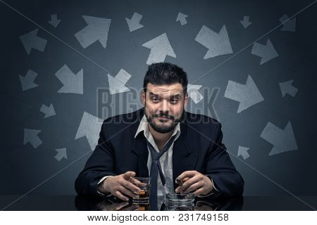 Drunk disappointed man sitting at table with arrows around
