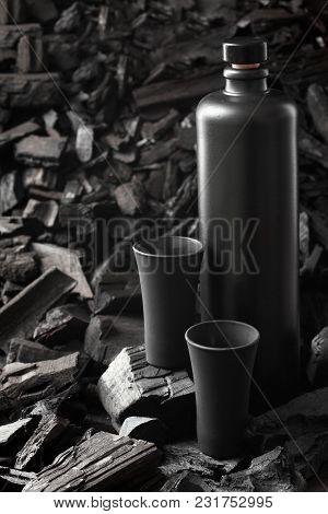 Original Black Matte Bottle Of Vodka Or Tequila And Black Shot Glass .on Charcoal Background. Black