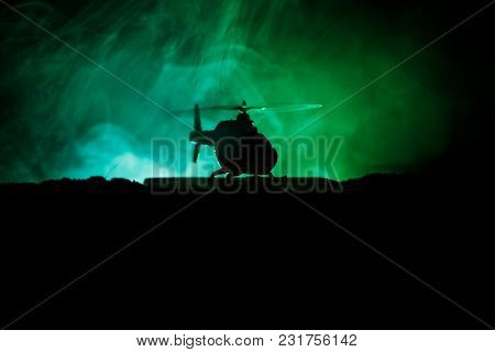 Silhouette Of Military Helicopter Ready To Fly From Conflict Zone. Decorated Night Footage With Heli