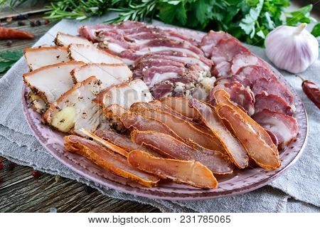 Big Meat Set. Homemade Smoked Pork-beef Sausage, Salted Bacon, Basturma Chopped Slices On A Wooden B
