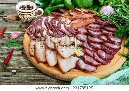 Big Meat Set. Homemade Smoked Pork-beef Sausage, Salted Bacon, Basturma Chopped Slices On A Wooden B