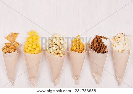 Snacks Collection In Craft Paper Cornets On White Wooden Board, Top View, Border.