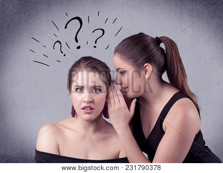 A teenager girl looking confused with drawn question marks above the head, while a girlfriend whispers something in her ear concept.