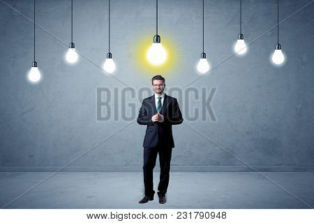 Handsome businessman in an empty space with bulbs above and uninspired face