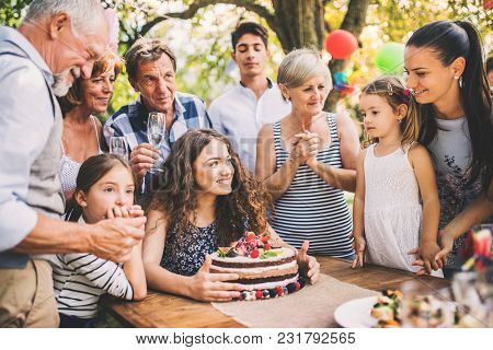 Family Celebration Outside In The Backyard.big Garden Party. Birthday Party. A Teenage Girl With A B