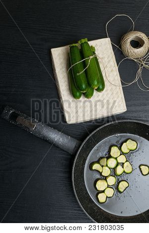 Cooked Vegetarian Food. Fried With Olive Oil Sliced Zucchini On Pan On A Rough Wood. And Raw Organic
