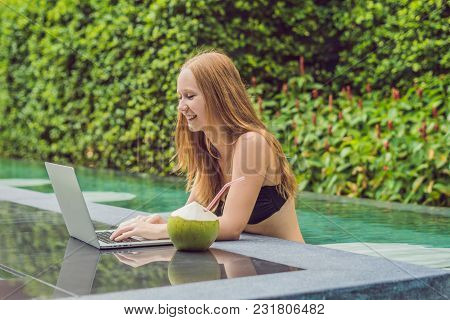 Young Female Freelancer Sitting Near The Pool With Her Laptop. Busy At Holidays. Distant Work Concep