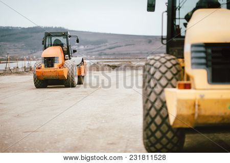 Vibratory Soil Compactor During Road And Highway Construction. Industrial Roadworks With Heavy-duty 