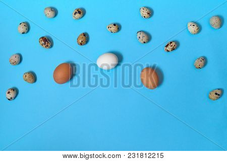 Border Of White, Brown And Quial Eggs On Blue Background, Copy Space. Healthy Food Concept. Top View