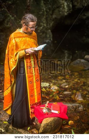 KOH CHANG, THAILAND - MAR 9, 2018: Orthodox priest during sacrament of spiritual birth - Baptism. There are currently 10 Orthodox parishes in Thailand, Orthodoxy is practiced by 0.002% of population.
