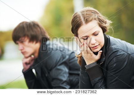 Relationship trouble or problem. Depressed woman and man in park