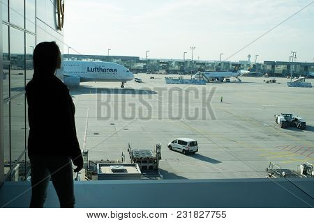 Frankfurt Am Main, Germany - October 11, 2015: Woman In Airport. Girl Silhouette Look At Planes On A