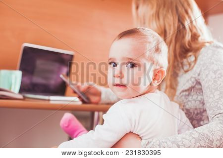 Baby Girl Is Sitting On Mothers Khees And Helps Mother To Work