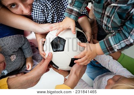 The Group Of Little Kids Quarrel Over A Ball. Children In Hysterics, Because One Boy Intercepted The