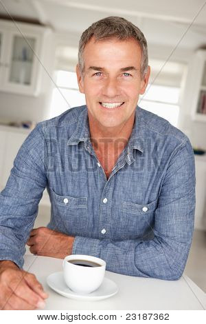 Midden leeftijd man met koffie thuis