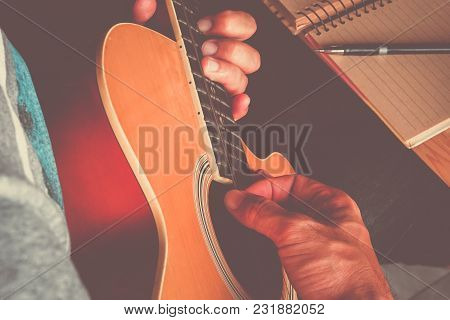 Man Composing A Song And Play Guitar With Paper