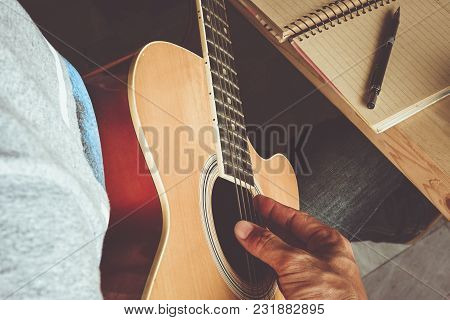 Man Composing A Song And Play Guitar With Paper
