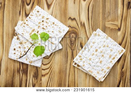 An Overhead Photo Of Matzah Or Matza Pieces And A Small Spring Fresh Linden Tree Branch. Matzah On T